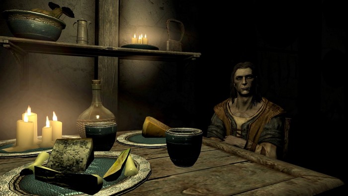Man sitting at a table with food and drink in The Elder Scrolls V Skyrim