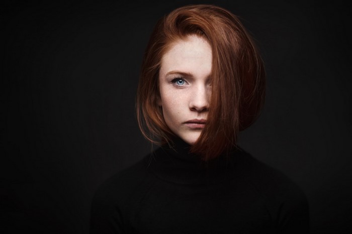 Redhead woman with blue eyes in black turtleneck