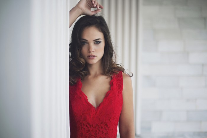 Woman in red lace dress with wavy brown hair
