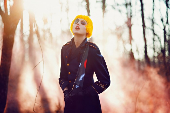 Woman with yellow wig and eyepatch in military uniform