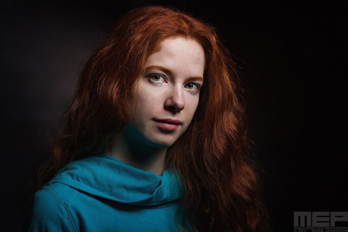 Portrait of a young redhead woman with green eyes