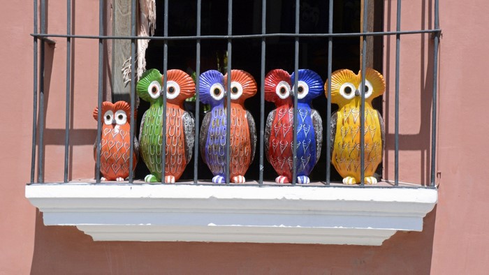 Colorful ceramic owls on a balcony