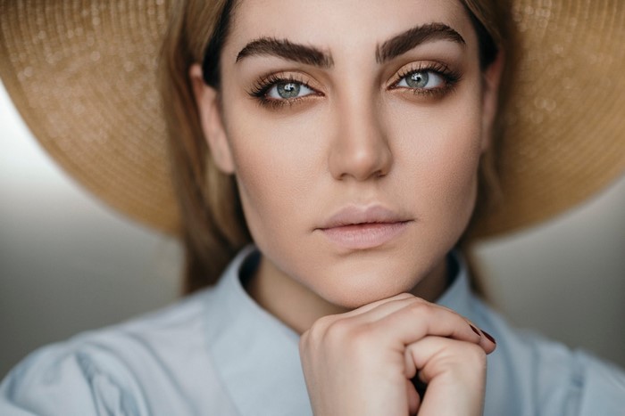 Woman wearing a straw hat and blue shirt