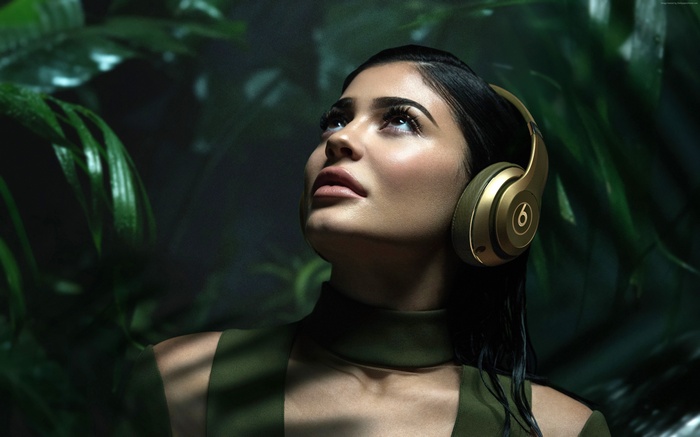 Kylie Jenner wearing gold Beats headphones in jungle