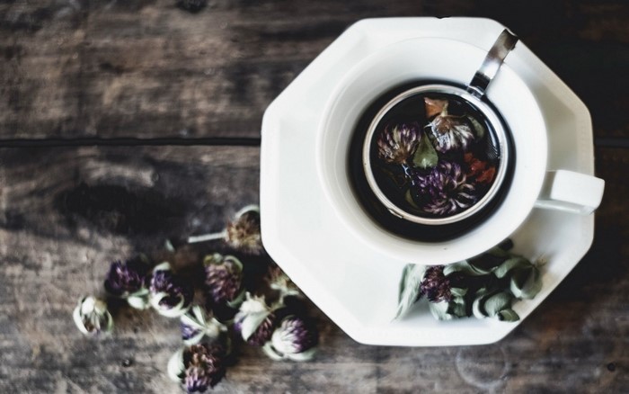 Herbal tea with clover flowers on a wooden table