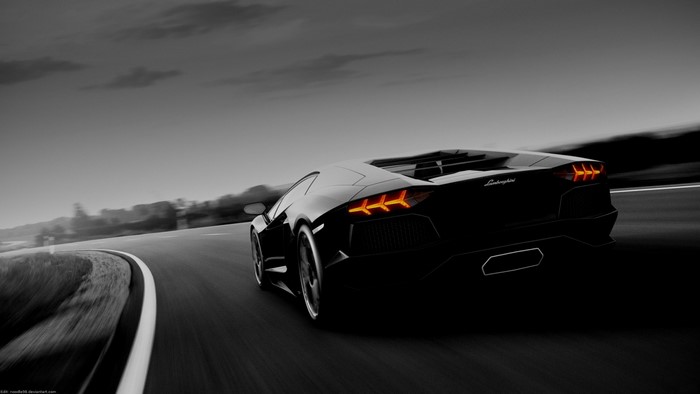 Black Lamborghini Aventador driving on a road