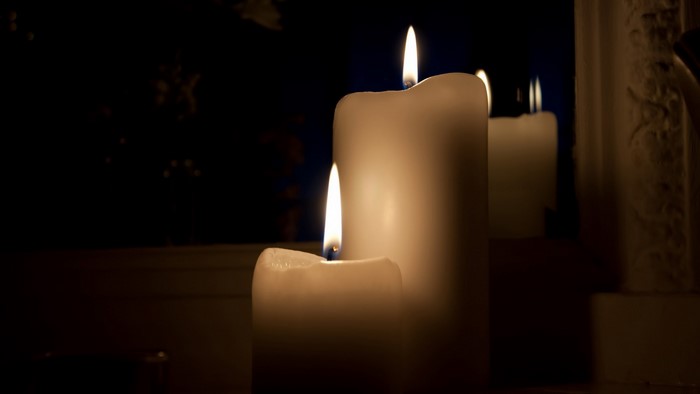 Three lit candles in the dark