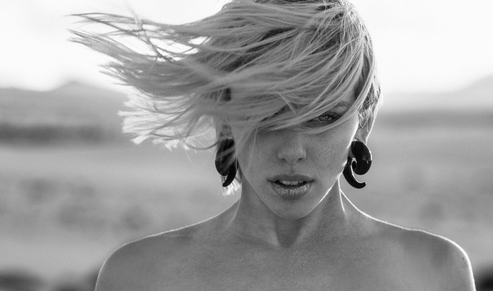 Monochrome portrait of a woman with windblown hair and large earrings