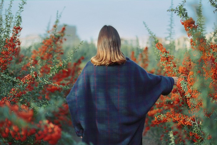Woman in poncho in berry bushes