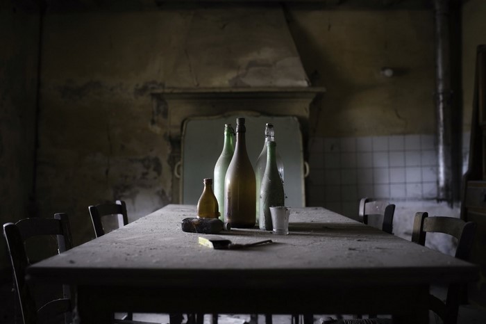 Bottles on a dusty table in an abandoned room
