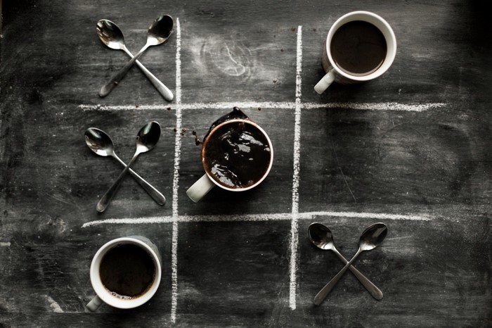 Tic-tac-toe game with coffee cups and spoons