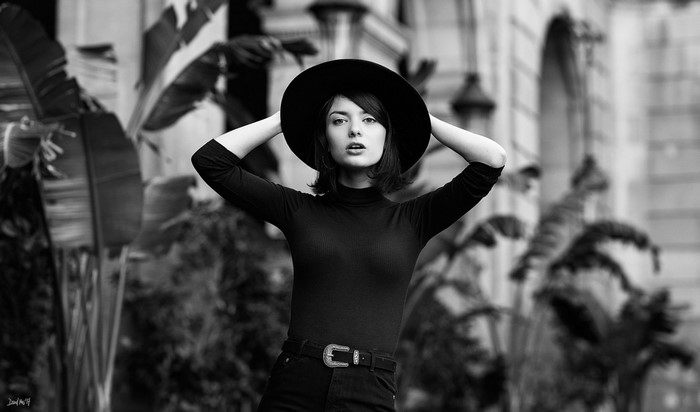 Woman in black hat and turtleneck, arms up