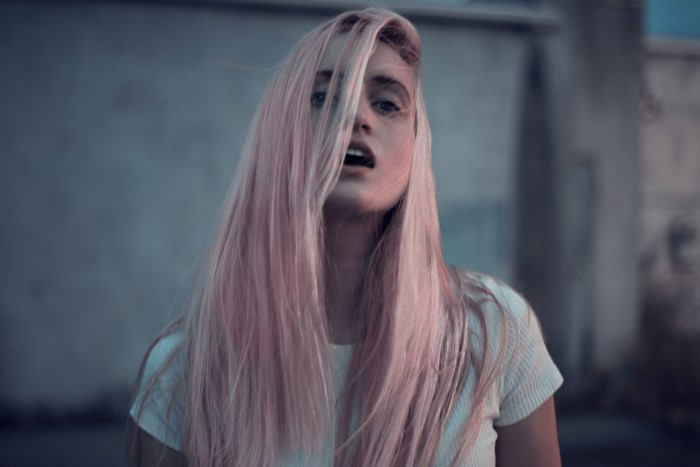 Woman with pink hair in a white t-shirt