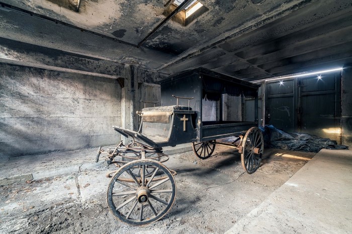 Abandoned horse-drawn hearse in a derelict building