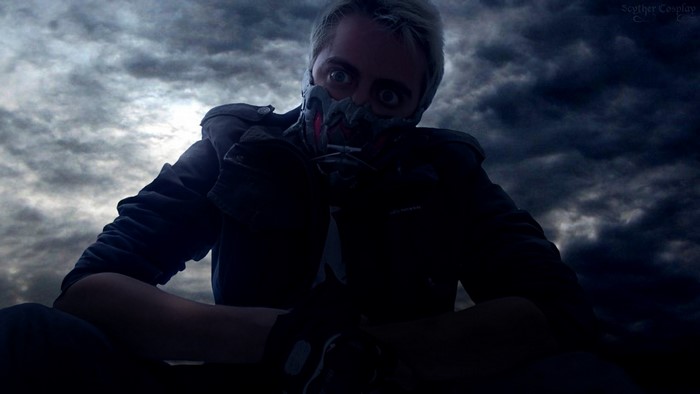 Man in mask against dark clouds
