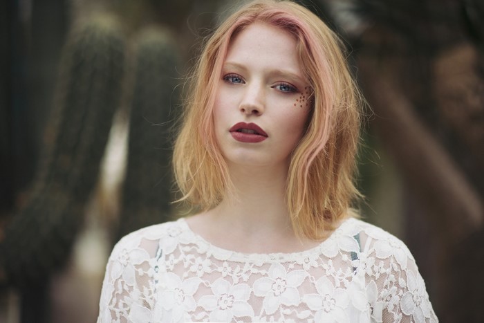 Woman with pink-tinted blonde hair and red lipstick