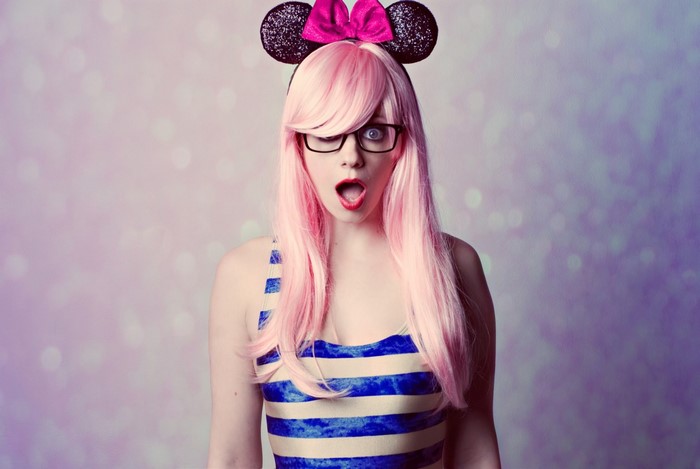 Woman with pink hair and Mickey Mouse ears