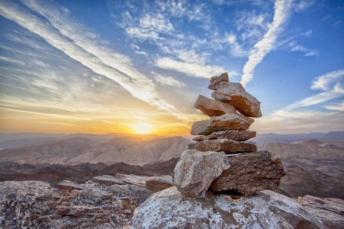 Stacked rocks on a mountain summit at sunrise
