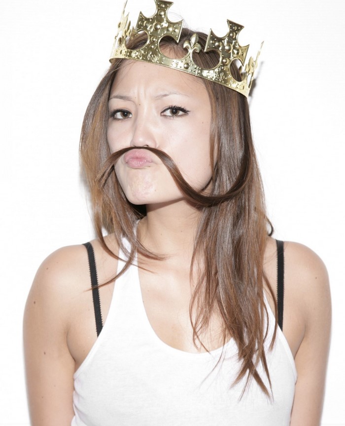 Woman wearing a crown with hair as mustache
