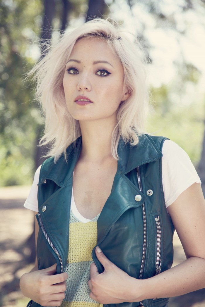 Pom Klementieff wearing a green vest and white shirt
