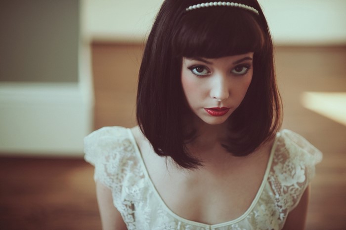 Woman with dark hair and white dress