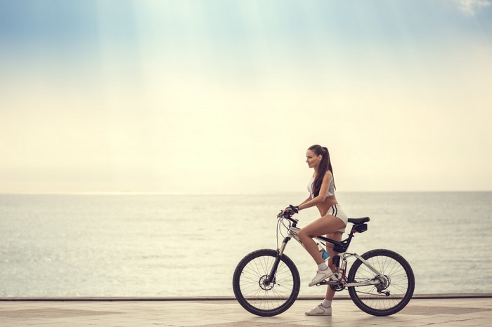 Woman riding a bicycle by the sea