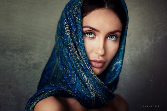 Woman with blue scarf and striking blue eyes
