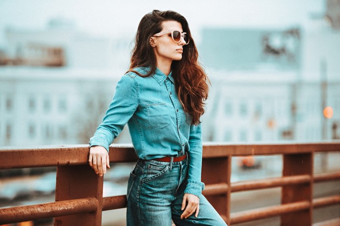 Woman wearing denim shirt and jeans with sunglasses
