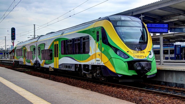 Green and yellow train at a Polish railway station