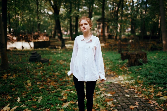 Woman in white shirt and black pants in autumn forest