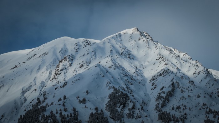 Snow-covered mountain peaks under a cloudy sky