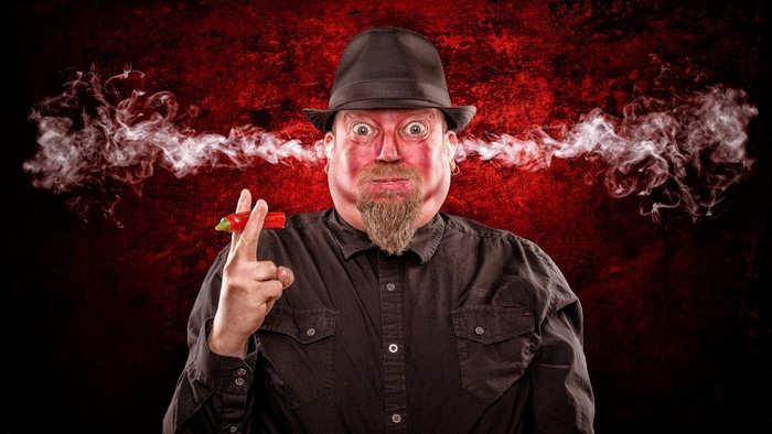 Man with chili pepper and smoke from ears