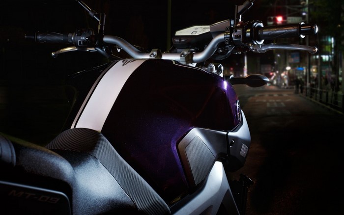Yamaha MT-09 motorcycle handlebars and fuel tank at night