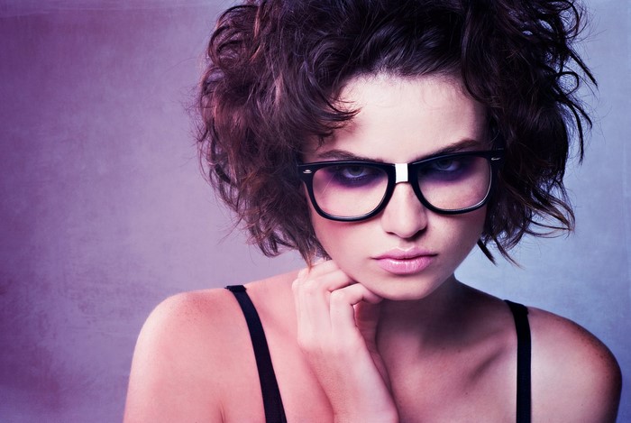 Woman with messy brown hair and glasses