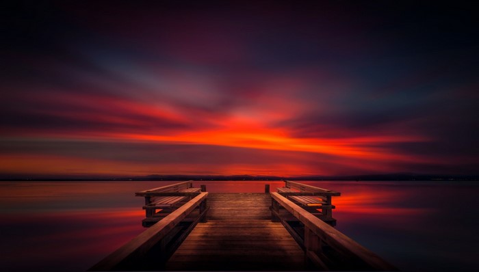 Wooden pier on a lake during a vibrant sunset