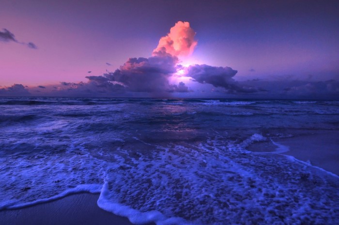 Sunset Over Calm Ocean Waves with Dramatic Clouds