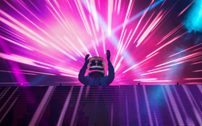 DJ Marshmello performing on stage with neon lights