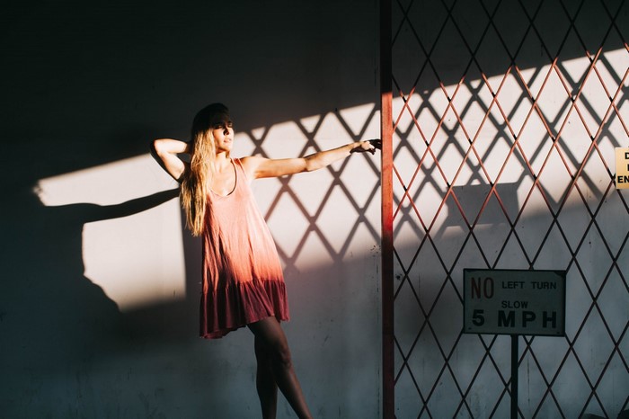 Woman in pink dress in sunlight with shadows