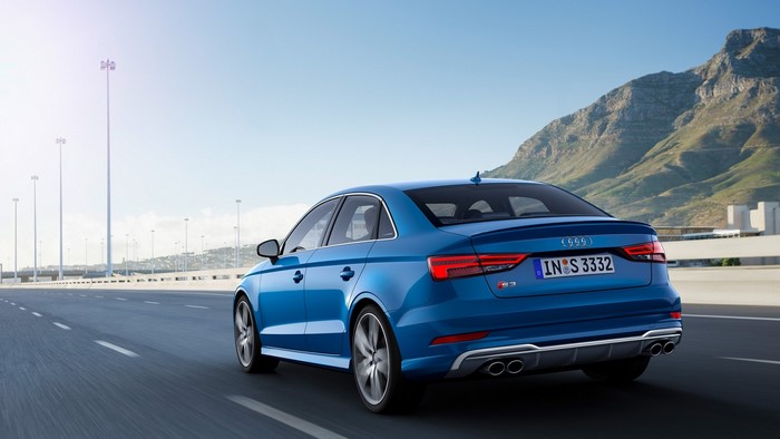 Blue Audi S3 Sedan driving on a highway with mountains