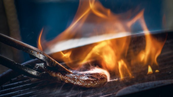 Meat on grill with flames