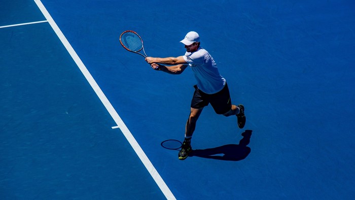 Andy Murray playing tennis on a blue court