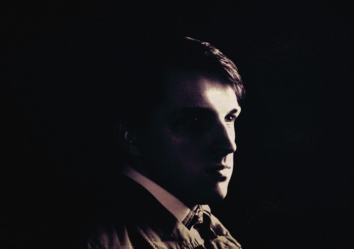 Man in dark suit with dramatic lighting