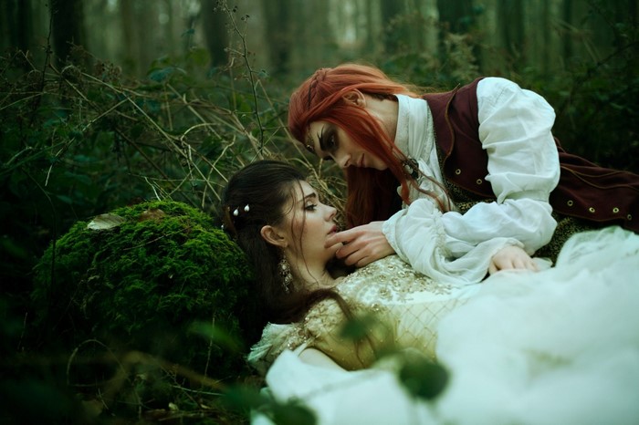 Two women in fantasy attire in a forest
