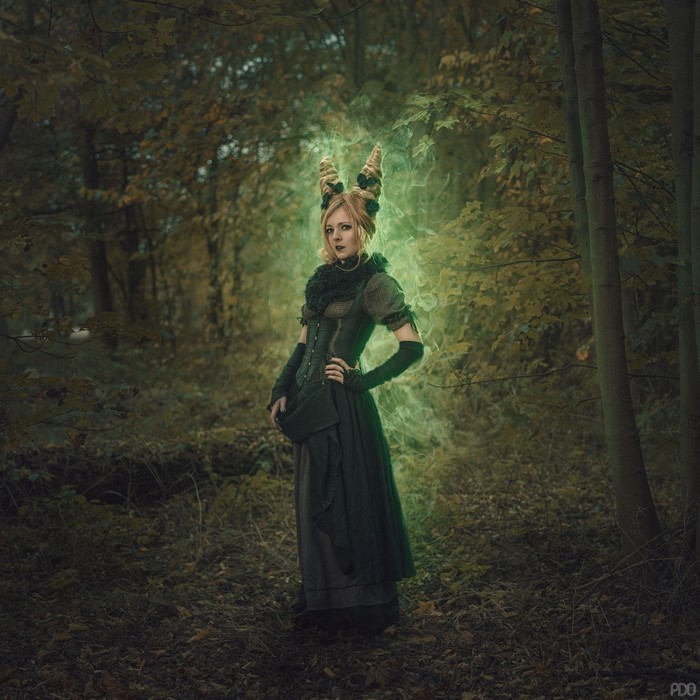 Fantasy girl with horns in a dark forest