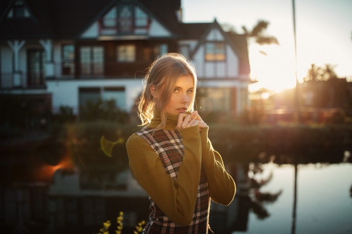 Woman in turtleneck and plaid dress in sunlight