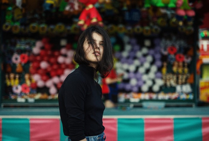 Woman in black turtleneck at a carnival game booth