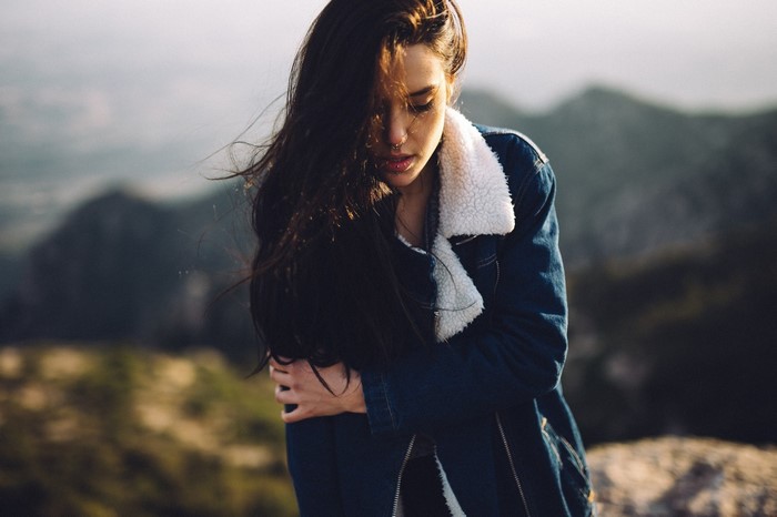 Woman in denim jacket with fur collar outdoors