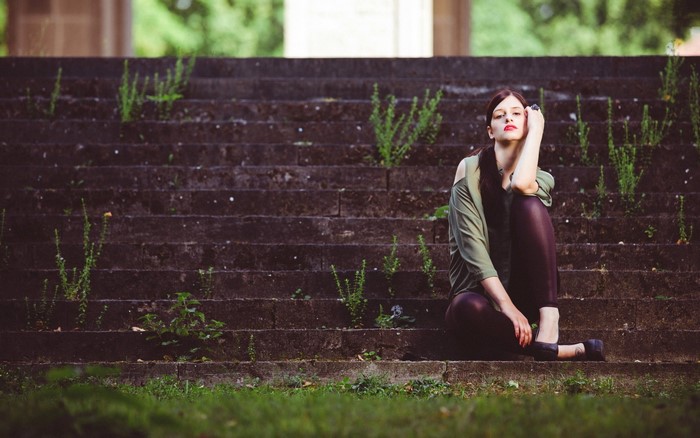Woman sitting on stone stairs outdoors