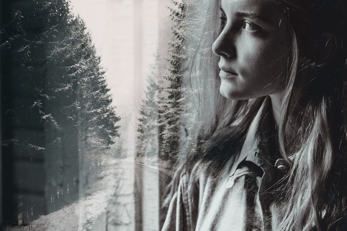 Double exposure of a woman and a winter forest