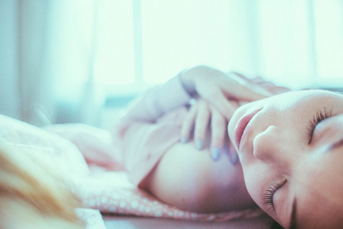 Woman with closed eyes lying on bed
